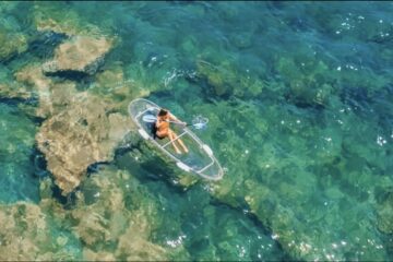 Una persona che si gode una tavola da paddleboard trasparente.