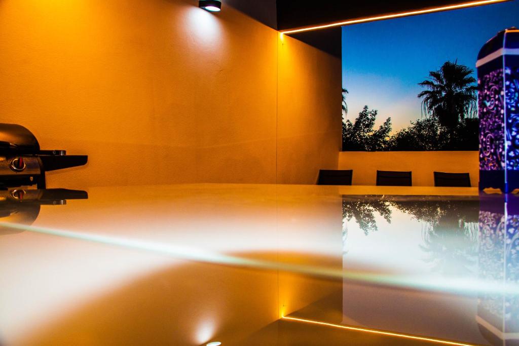 Una scena rilassante di uno spazio esterno con piscina illuminata da luci calde e moderne.