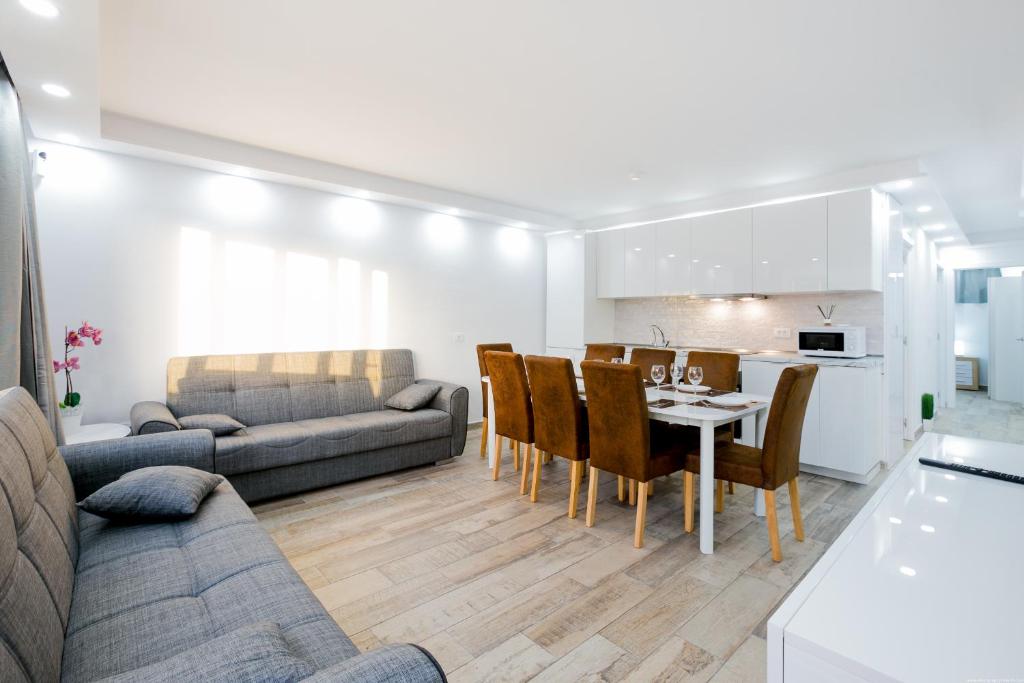 Un soggiorno e una cucina. Il design è minimalista e luminoso.